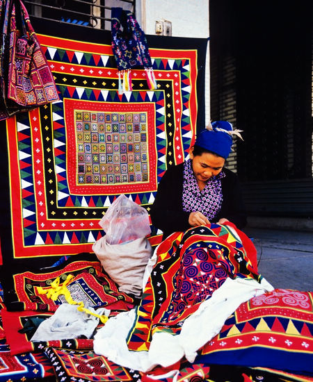 Miao women embroider patterns on clothes